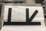 A Black Custom Support Bracket with two arms coming out horizontally at a 90-degree angle and one arm at a 45-degree angle, laying on packing paper on a concrete floor.