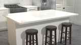 A side view of a white marble island countertop with three dark brown barstools lined up under the counter on a gray tile floor with a stainless steel refrigerator and stove in the background.