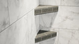 Two original corner shower shelves covered in gray tile attached to a marble bathroom wall.