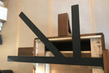 A Black Custom Support Bracket in a ‘K’ shape on a dark brown wooden countertop.